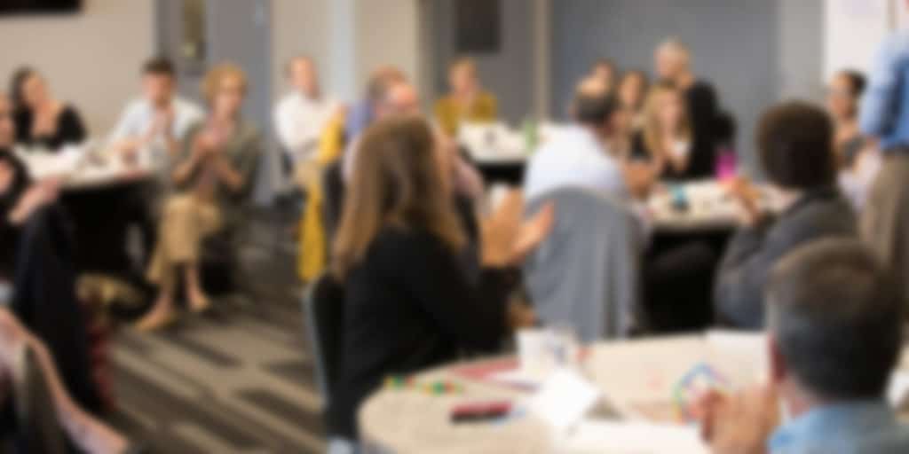 Blurred banner image of Public Sector Consultants' staff in an annual company strategy meeting