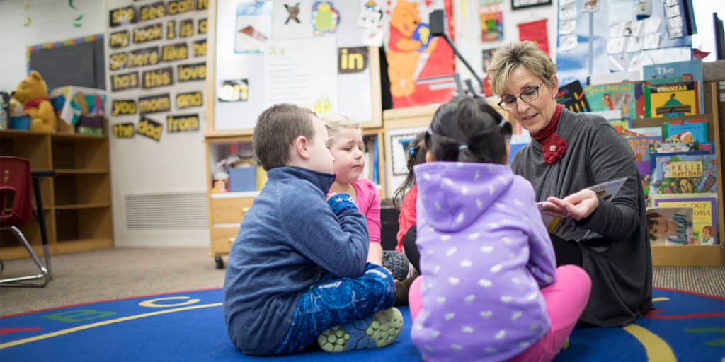 Young students being read a story by their teacher.