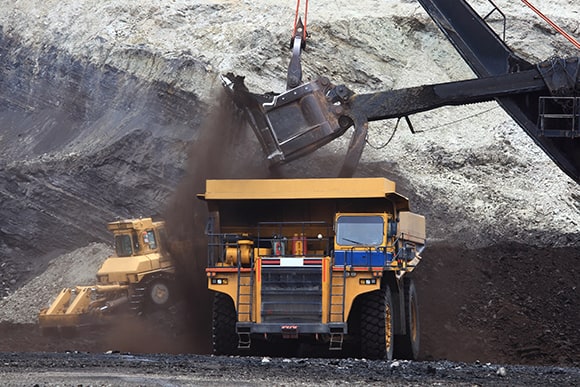 A large dump truck getting filled with coal