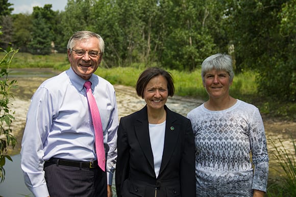 Three people standing by a watershed preserve