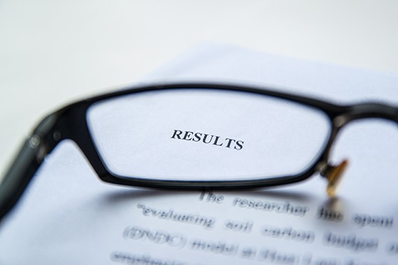 Eyeglasses resting on a report focusing on a title called "results"