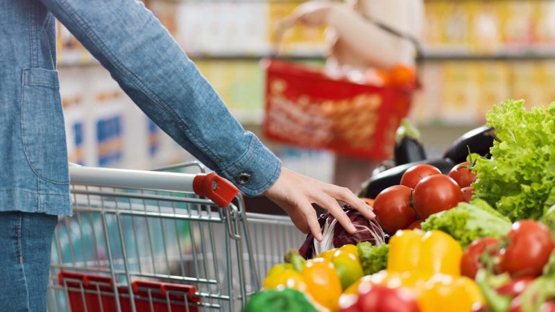 Woman at the grocery store, she is buying fresh vegetables in the produce section, hands close up